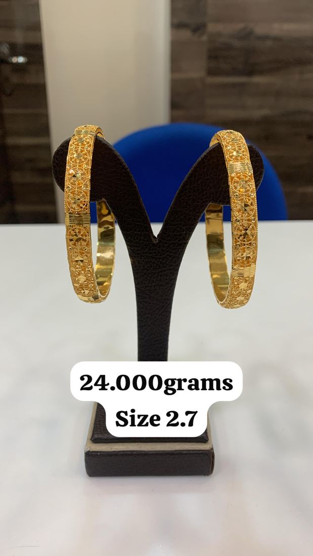 Pair of gold bangles on a display stand