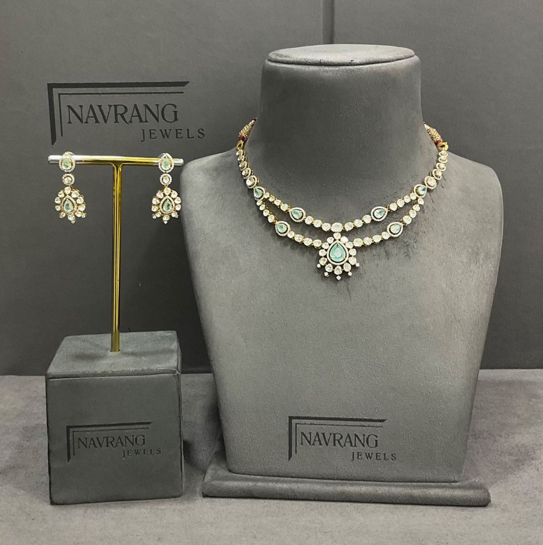 Diamond necklace set with green stones and matching earrings