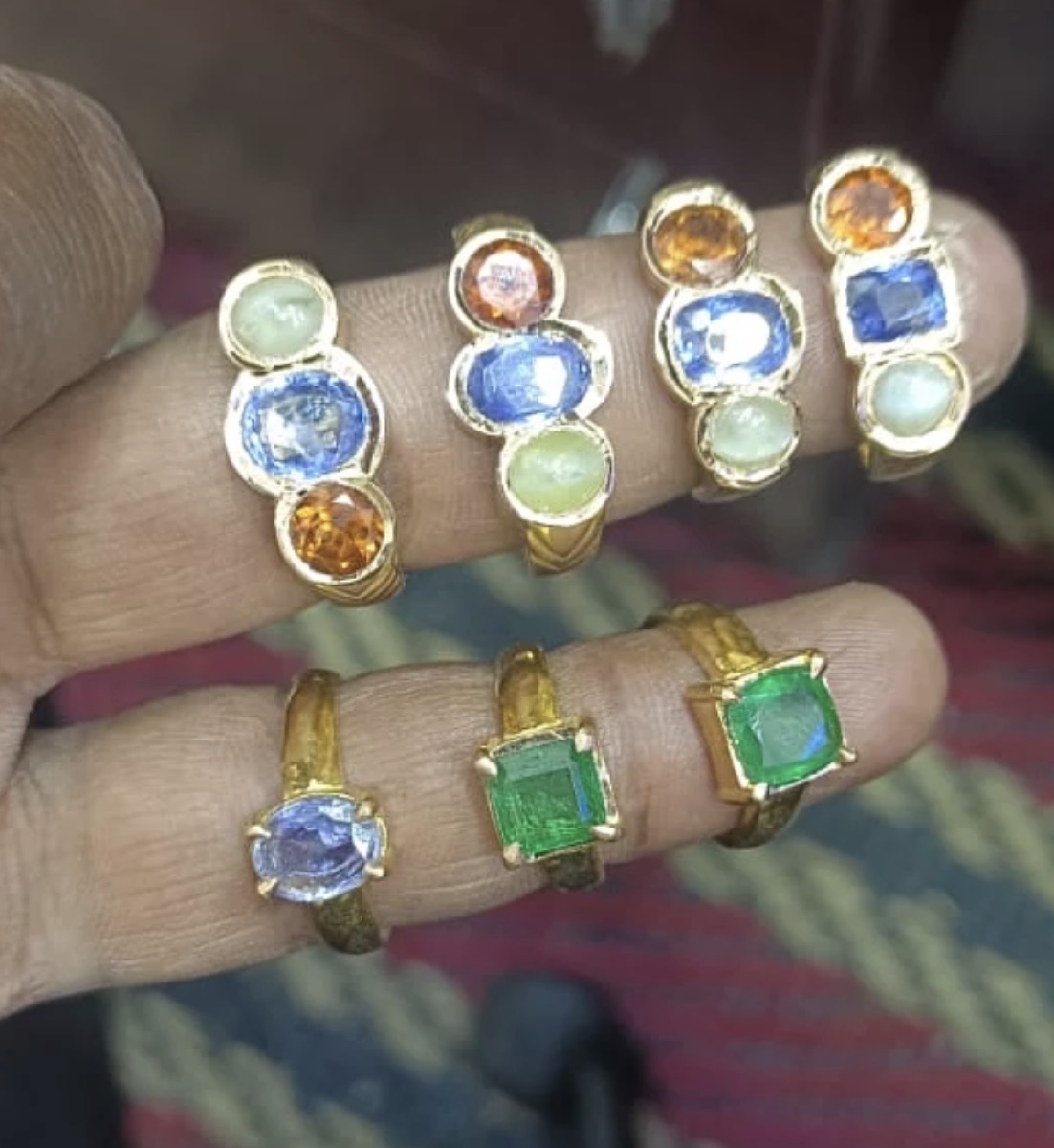 Gold rings set with blue, green and orange stones